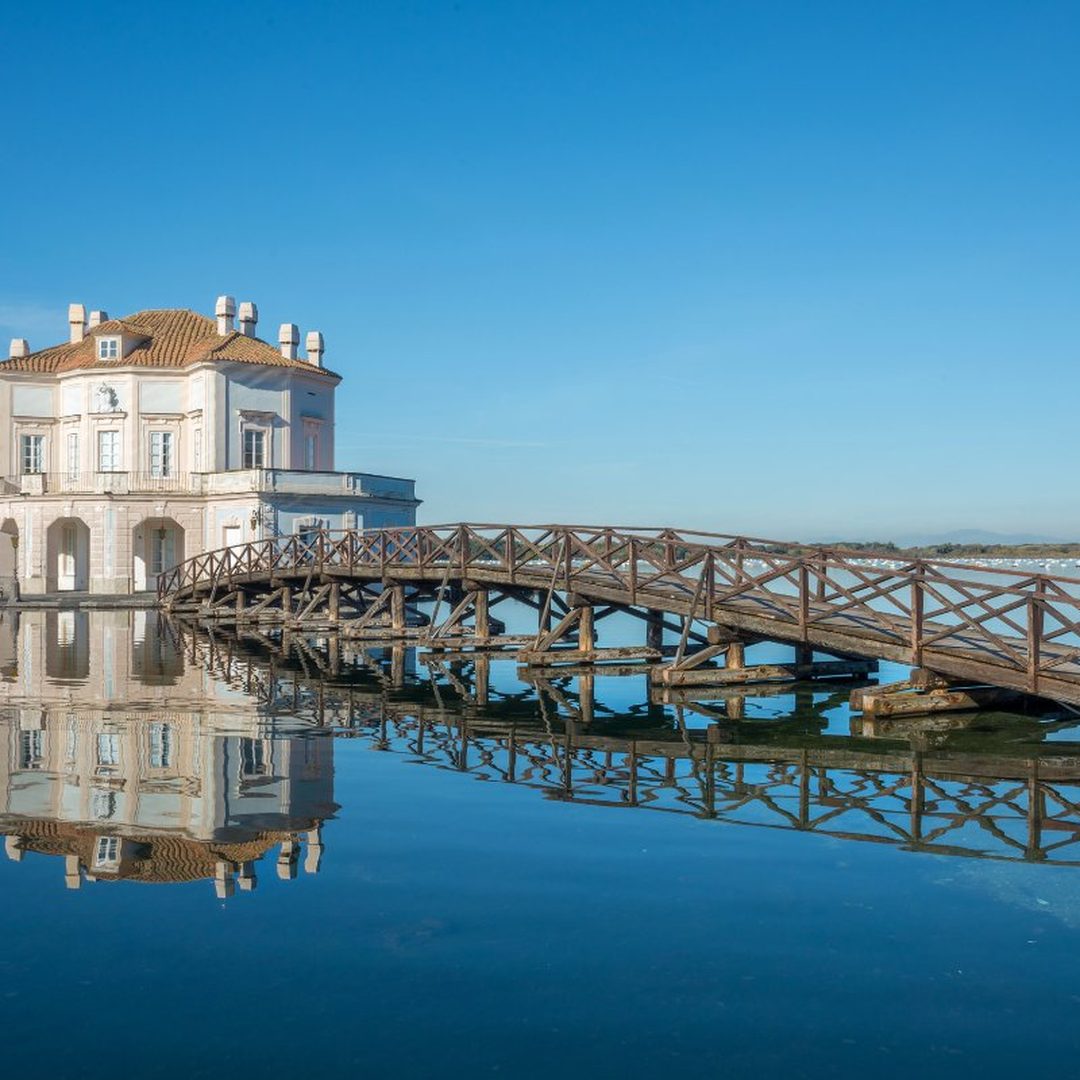 The Casina Vanvitelliana, a delicate Bourbon-era pavilion standing on Lake Fusaro at Bacoli, linked to shore by a wooden bridge